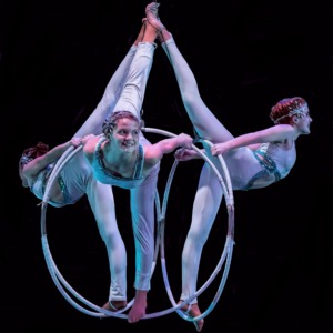 Elegant circus performers with hoops, showcasing acrobatic artistry on stage.