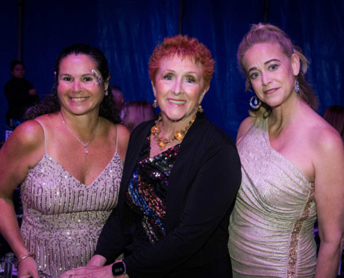 Elegant women at circus staging event with vibrant costumes and jewelry.