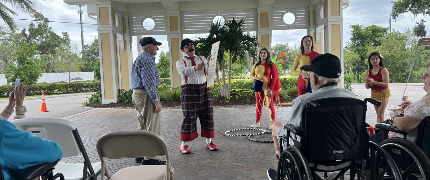 slider2 Circus staging with performers entertaining an audience outdoors in a covered pavilion.