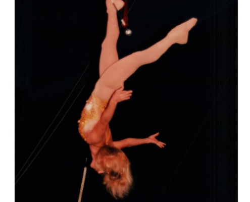 Aerial acrobat performing on a circus aerial silks rig for circus staging and performance art.