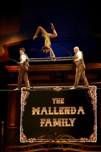 Acrobats performing on tightrope with a dynamic background at a circus.