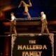Acrobats performing on tightrope with a dynamic background at a circus.