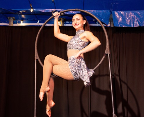 Circus aerialist performing on a hoop, showcasing circus staging and acrobatics skills.