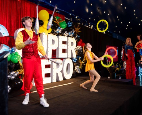 Juggling performance on circus stage with performers in colorful costumes at Circus Arts OSTG.