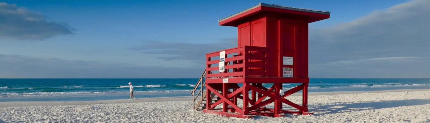 Red beach lifeguard tower on sandy shore with ocean background, seaside safety station, coastal emergency structure, oceanfront lifeguard station, seaside safety equipment, outdoor beach scene, coastal rescue station, ocean view lifeguard hut, tropical beach lifeguard post, scenic seaside safety shelter.